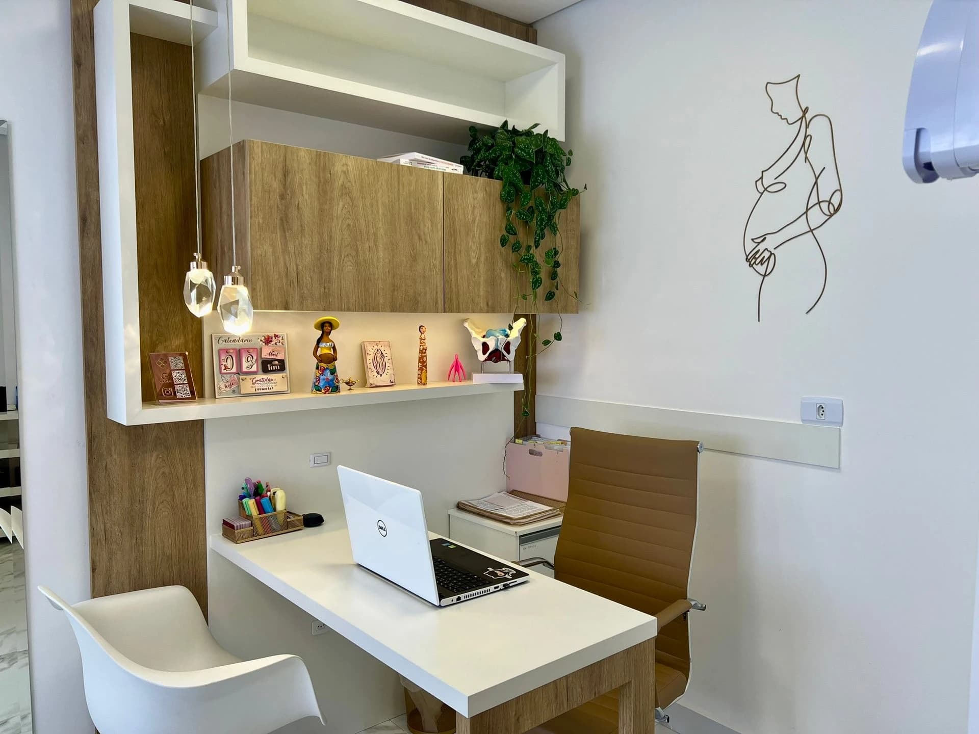 Sala de atendimento da Clínica Vittalice — escrivaninha, plantas e desenho de gestante na parede